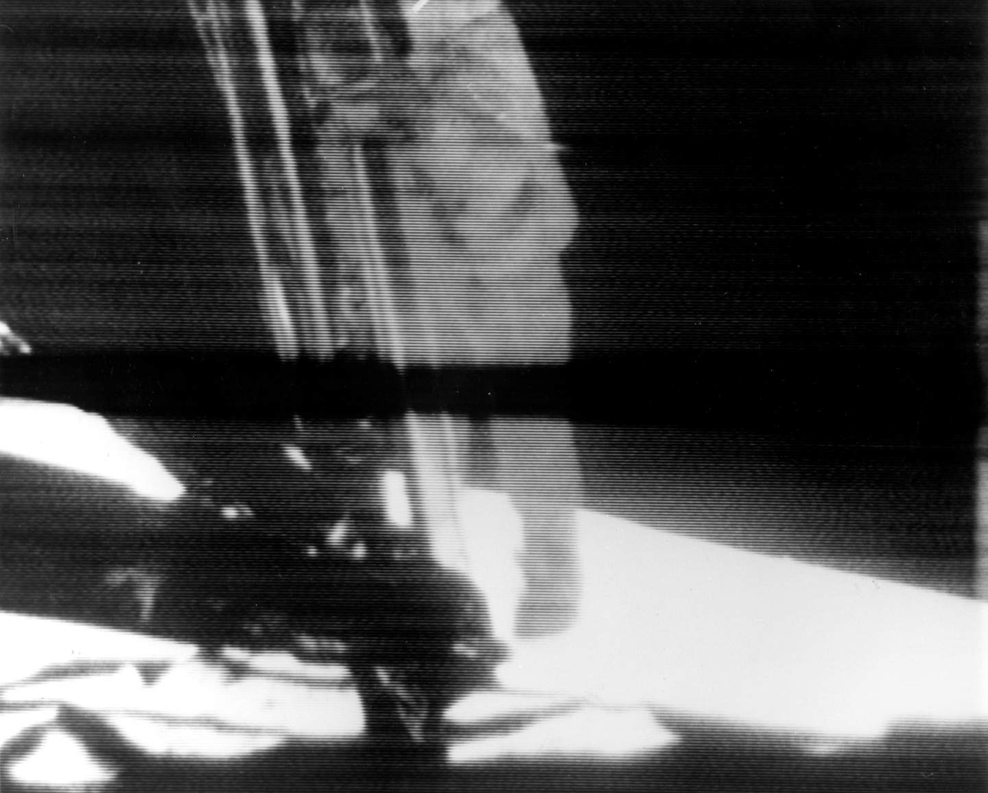 black and white tv footage of astronaut climbing down ladder of lunar module