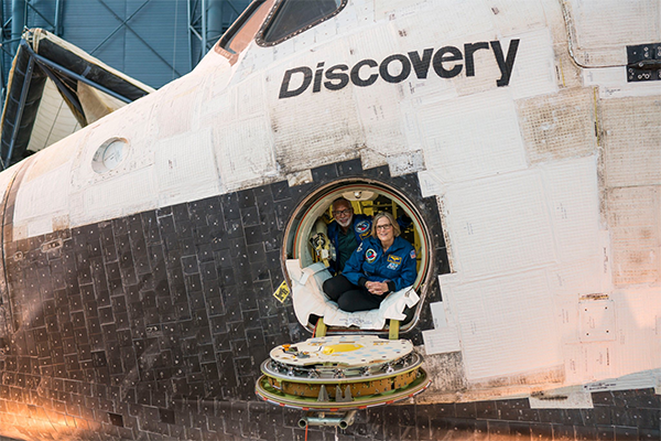 Astronauts looking out of the Space Shuttle Discovery's hatch